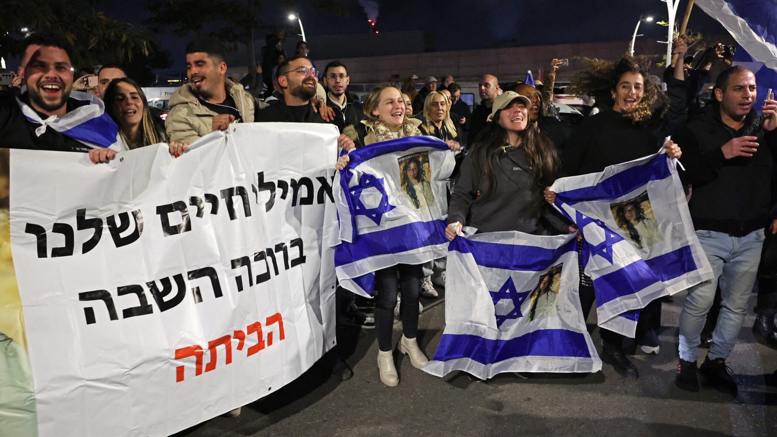 Supporters and friends of Emily Damari, one of the three Israeli hostages abducted on 7 October 2023, cheer upon her arrival outside the Sheba medical centre in Ramat Gan near Tel Aviv on 19 January 2025.